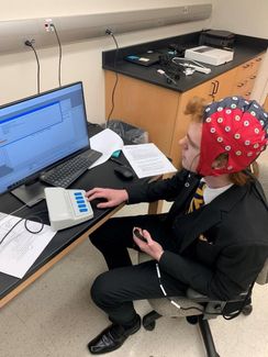 Former RAP student Parker Carte tests an  electroencephalogram (EEG) for his research with Dr. Scott Galster at the Rockefeller Neuroscience Institute.